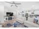 Bright living room features white sofas, TV, and opens to the kitchen, all under a ceiling fan at 422 Harbour View Dr., Myrtle Beach, SC 29579
