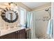 Updated bathroom with a modern vanity, designer mirror, and tiled walk-in shower with a rainfall shower head at 466 Wampee St. Nw, Calabash, NC 28467