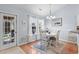 Cozy dining area features a round table, wood floors, modern chandelier, and natural light from the windows at 466 Wampee St. Nw, Calabash, NC 28467