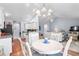 Open concept dining area with wood floors, chandelier, and open view to the living area and kitchen at 466 Wampee St. Nw, Calabash, NC 28467