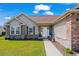 Inviting front entrance featuring a well-manicured lawn, brick accents, and a charming white door at 466 Wampee St. Nw, Calabash, NC 28467