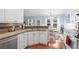 Kitchen features stainless appliances, white cabinets, granite countertops, backsplash, and wood flooring at 466 Wampee St. Nw, Calabash, NC 28467