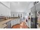 Open kitchen and dining area featuring stainless steel appliances, white cabinets, and wood floors at 466 Wampee St. Nw, Calabash, NC 28467