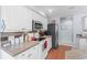 Well-lit kitchen showcasing stainless steel appliances, white cabinetry, granite countertops, and wood flooring at 466 Wampee St. Nw, Calabash, NC 28467