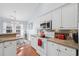 Well-equipped kitchen and dining area showcasing stainless appliances, white cabinets, granite countertops, and wood flooring at 466 Wampee St. Nw, Calabash, NC 28467