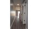 Hallway with wood floors leading to a bright, sunlit doorway, and white doors for access at 573 Blue River Ct. # 8-H, Myrtle Beach, SC 29579