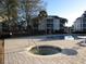 A hot tub and community pool sits in a paved area beside grass and residences on a sunny day at 573 Blue River Ct. # 8-H, Myrtle Beach, SC 29579