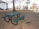 Community picnic area with a green metal table and benches beside the pond on a sunny day at 573 Blue River Ct. # 8-H, Myrtle Beach, SC 29579