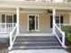Covered front entry with brick steps, white railings, and a glass storm door at 9500 Indigo Creek Blvd., Murrells Inlet, SC 29576