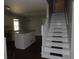 Living room with open kitchen, white stairs, and wood floor at 9500 Indigo Creek Blvd., Murrells Inlet, SC 29576
