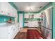 Bright kitchen featuring green walls, white cabinets, stainless steel appliances, and wood-look floors at 634 Melody Ln., Surfside Beach, SC 29575