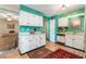 Well-lit kitchen with white cabinets, green accent walls, and views into the dining area at 634 Melody Ln., Surfside Beach, SC 29575