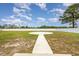 Expansive backyard with a circular concrete pad and a walkway, enclosed by a white privacy fence at 6392 Highway 378, Conway, SC 29527