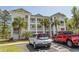 A multi-story residence with bright balconies offers an inviting facade complemented by beautiful landscaping and palm trees at 646 Tupelo Ln. # 4E, Longs, SC 29568