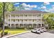Inviting condo exterior features balconies, manicured lawn, and ample parking at 679 Riverwalk Dr. # 201, Myrtle Beach, SC 29579
