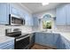 Modern kitchen features stainless steel appliances and stylish blue cabinetry at 679 Riverwalk Dr. # 201, Myrtle Beach, SC 29579