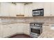 Traditional kitchen features cream cabinets, tiled backsplash, granite countertops, and stainless steel appliances at 808 East Coast Ln., North Myrtle Beach, SC 29582