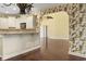 Open kitchen featuring white cabinetry and a breakfast bar, connecting to a separate space with patterned wallpaper at 808 East Coast Ln., North Myrtle Beach, SC 29582