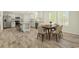 Modern kitchen with stainless steel appliances, wood-look floors, a dining area, and white cabinets at 814 S Midway Hwy., Johnsonville, SC 29555