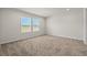 A bright bedroom features a neutral carpet and two windows with outside views at 820 S Midway Hwy., Johnsonville, SC 29555