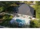Aerial view of backyard with pool and spa, surrounded by lush greenery and a white picket fence at 8261 Timber Ridge Rd., Conway, SC 29526