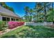 Landscaped backyard with a white picket fence and mature trees at 8261 Timber Ridge Rd., Conway, SC 29526