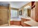 Well-lit bathroom features a soaking tub under a window and a glass enclosed shower at 8261 Timber Ridge Rd., Conway, SC 29526