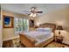 Comfortable bedroom features a rattan bed frame, ceiling fan, and plantation shutters for lots of light at 8261 Timber Ridge Rd., Conway, SC 29526
