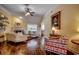 Cozy living room with hardwood floors, a ceiling fan, fireplace and large windows for natural light at 8261 Timber Ridge Rd., Conway, SC 29526