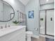 Well-lit bathroom featuring a walk-in shower, updated fixtures, a round mirror, and stylish decor at 8418 Cape Dutch Loop, Myrtle Beach, SC 29572