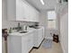 Bright laundry room with white cabinetry, a sink, and modern washer and dryer units at 8418 Cape Dutch Loop, Myrtle Beach, SC 29572