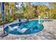 Backyard pool area with in-pool loungers and a hot tub surrounded by lush landscaping at 8418 Cape Dutch Loop, Myrtle Beach, SC 29572