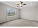 Bright carpeted bedroom with a tray ceiling, ceiling fan, and a large window offering peaceful views at 875 Owls Nest Dr., Conway, SC 29527