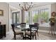 Bright dining room features a glass table, chandelier, neutral walls, and large windows at 1006 Surf Pointe Dr., North Myrtle Beach, SC 29582