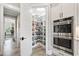 Walk-in pantry with custom shelving provides ample storage space, conveniently located near stainless steel ovens at 1006 Surf Pointe Dr., North Myrtle Beach, SC 29582