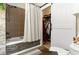 Bathroom featuring a tub with shower, tiled walls, and a sliding door leading to a walk-in closet at 101 Maddington Place Dr. # 103, Surfside Beach, SC 29575
