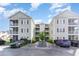 Three-story condo complex with screened porches, a manicured landscape, and ample parking space at 101 Maddington Place Dr. # 103, Surfside Beach, SC 29575
