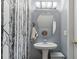 Stylish powder room with a pedestal sink, oval mirror, and black and white birch tree wallpaper at 1064 Penny Ln. # 1064, Myrtle Beach, SC 29577