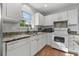 Well-lit kitchen with white cabinets, stainless steel sink, and wood flooring at 1064 Penny Ln. # 1064, Myrtle Beach, SC 29577