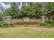 Elegant brick community entrance with lush landscaping and signage for 