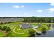 Community aerial view featuring lake, clubhouse, pool, pickleball courts, putting green and surrounding homes at 1239 Pyxie Moss Dr., Little River, SC 29566