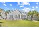 Backyard featuring a well-maintained lawn, mature palm tree, a screened porch and an outdoor patio area with seating at 1239 Pyxie Moss Dr., Little River, SC 29566