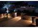 Tranquil backyard illuminated at night with landscape lighting highlighting a stone retaining wall and palm tree at 1239 Pyxie Moss Dr., Little River, SC 29566