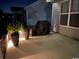 Backyard patio with potted plants, outdoor lighting, and a grill, perfect for evening gatherings at 1239 Pyxie Moss Dr., Little River, SC 29566