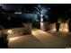 Backyard patio with retaining wall and manicured landscaping illuminated at night at 1239 Pyxie Moss Dr., Little River, SC 29566