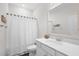 Bright bathroom with a shower featuring white tiling, large mirror, and modern vanity at 1239 Pyxie Moss Dr., Little River, SC 29566
