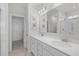 Bathroom with double sinks, framed mirror and a view to the walk-in closet and shower at 1239 Pyxie Moss Dr., Little River, SC 29566