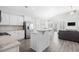 Stylish open-concept kitchen featuring white cabinets, granite countertops, stainless appliances, and an island with seating at 1239 Pyxie Moss Dr., Little River, SC 29566