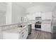 Modern kitchen with stainless steel appliances, granite countertops, white cabinetry, and sleek wood flooring at 1239 Pyxie Moss Dr., Little River, SC 29566
