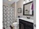 Cozy bathroom featuring shower with patterned curtain, framed mirror, and vanity with dark wood cabinets at 157 Egret Run Ln. # 514, Pawleys Island, SC 29585